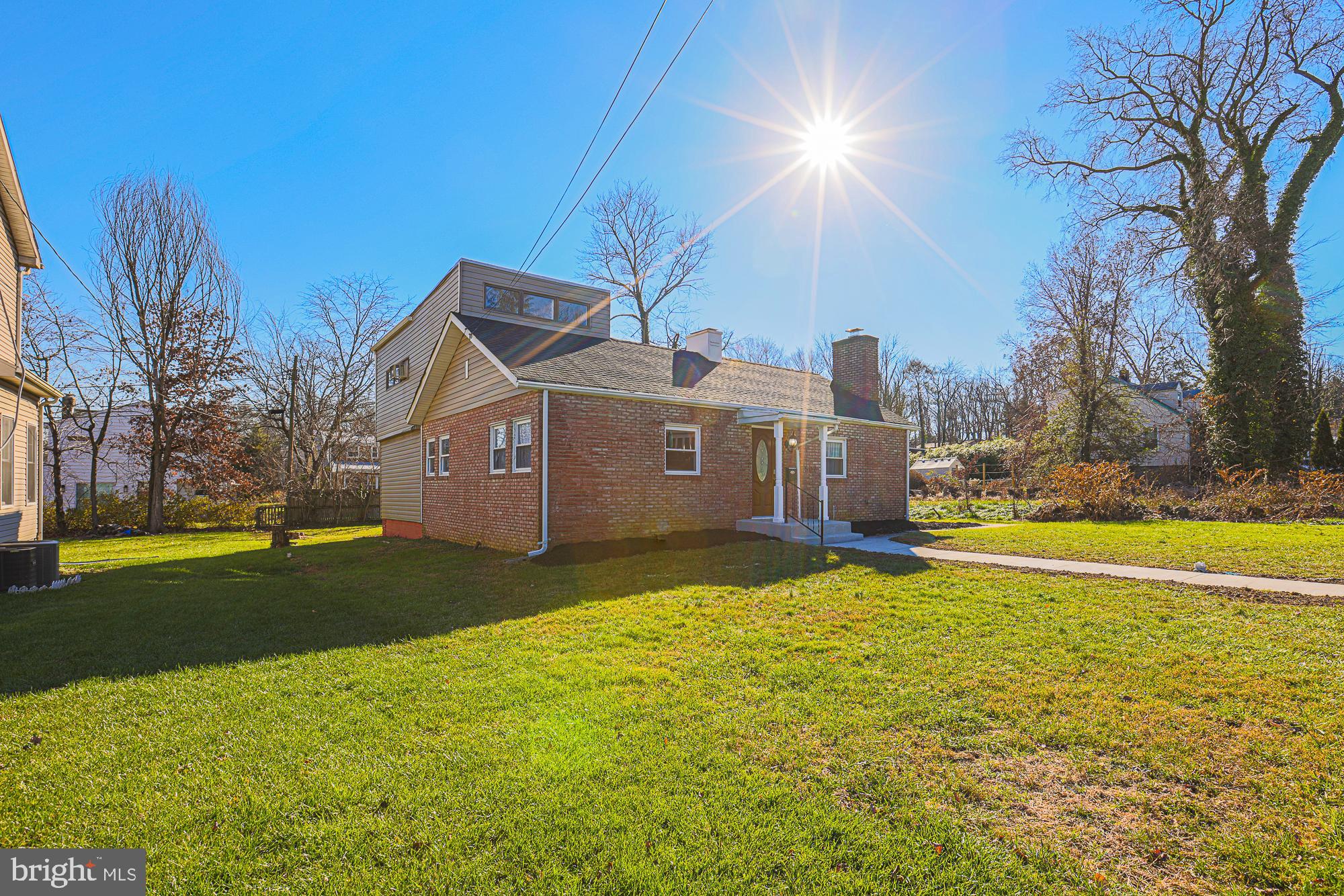 a front view of house with yard and trees in the background