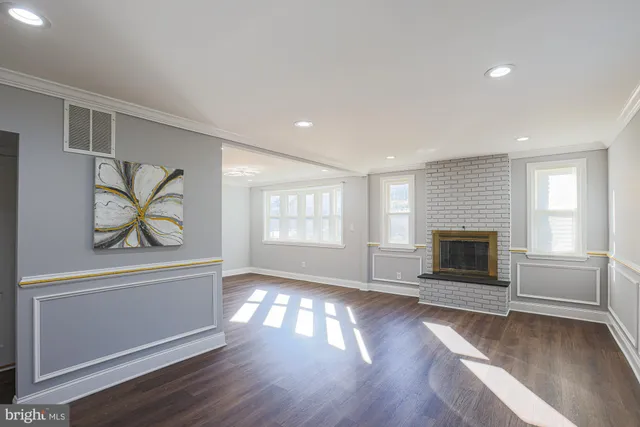 an empty room with windows and fireplace