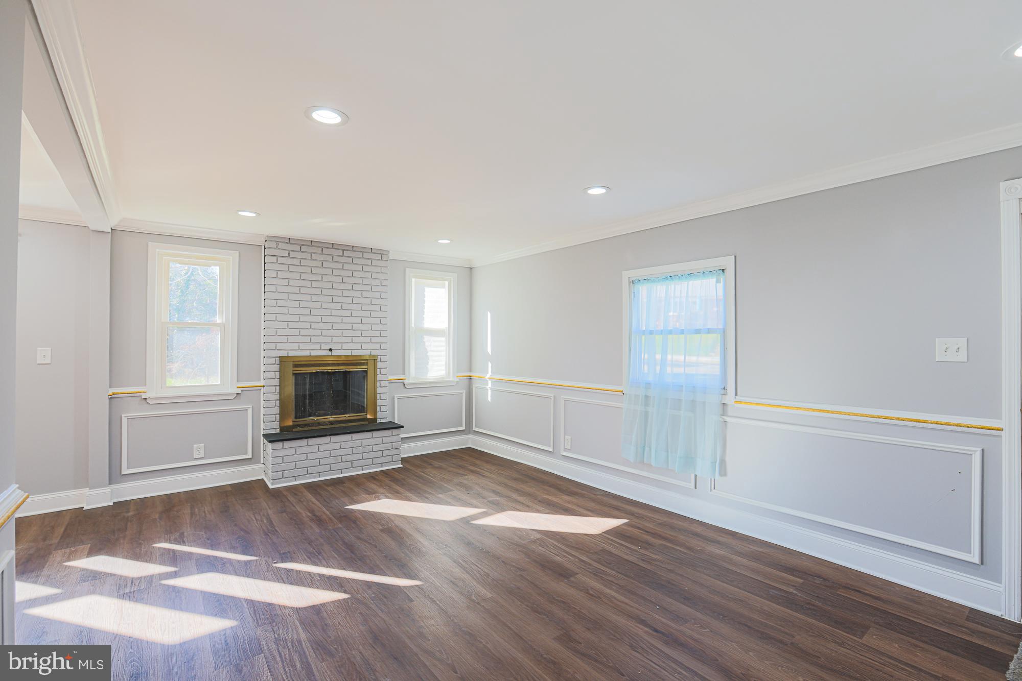 2507 Taney Road Baltimore, MD 21209 - Photo 12 of 58 a view of empty room with wooden floor and fireplace