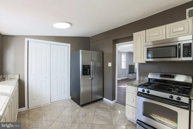 a kitchen with stainless steel appliances granite countertop a refrigerator and a stove top oven