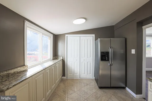 a kitchen with stainless steel appliances granite countertop a refrigerator and a sink