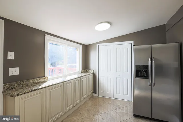 a kitchen with stainless steel appliances granite countertop a refrigerator and a sink