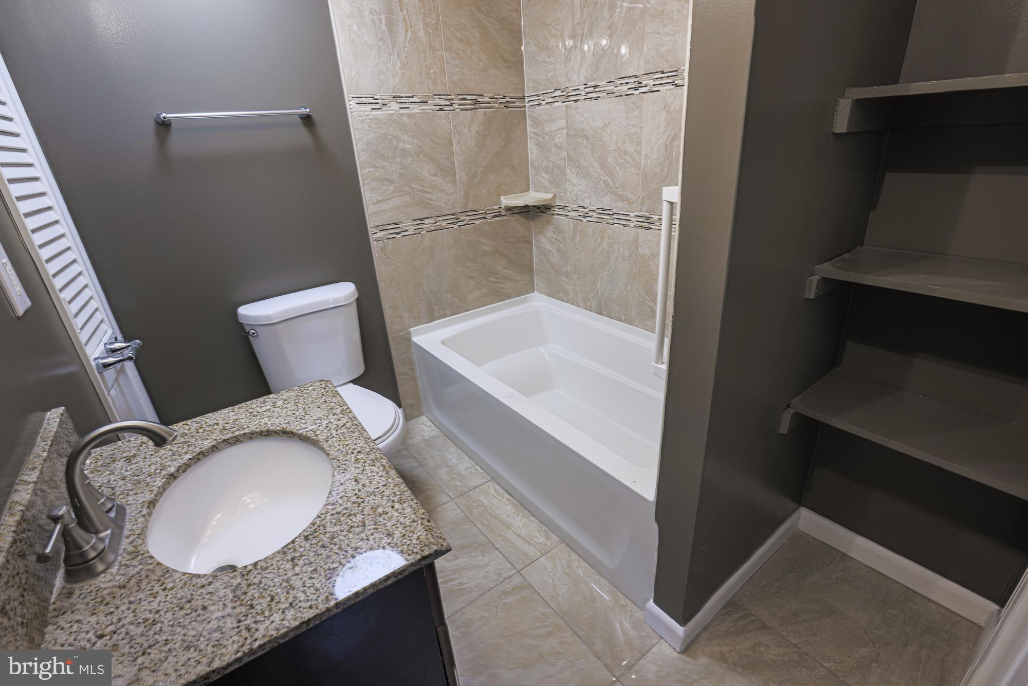2507 Taney Road Baltimore, MD 21209 - Photo 23 of 58 a bathroom with a granite countertop sink toilet and shower