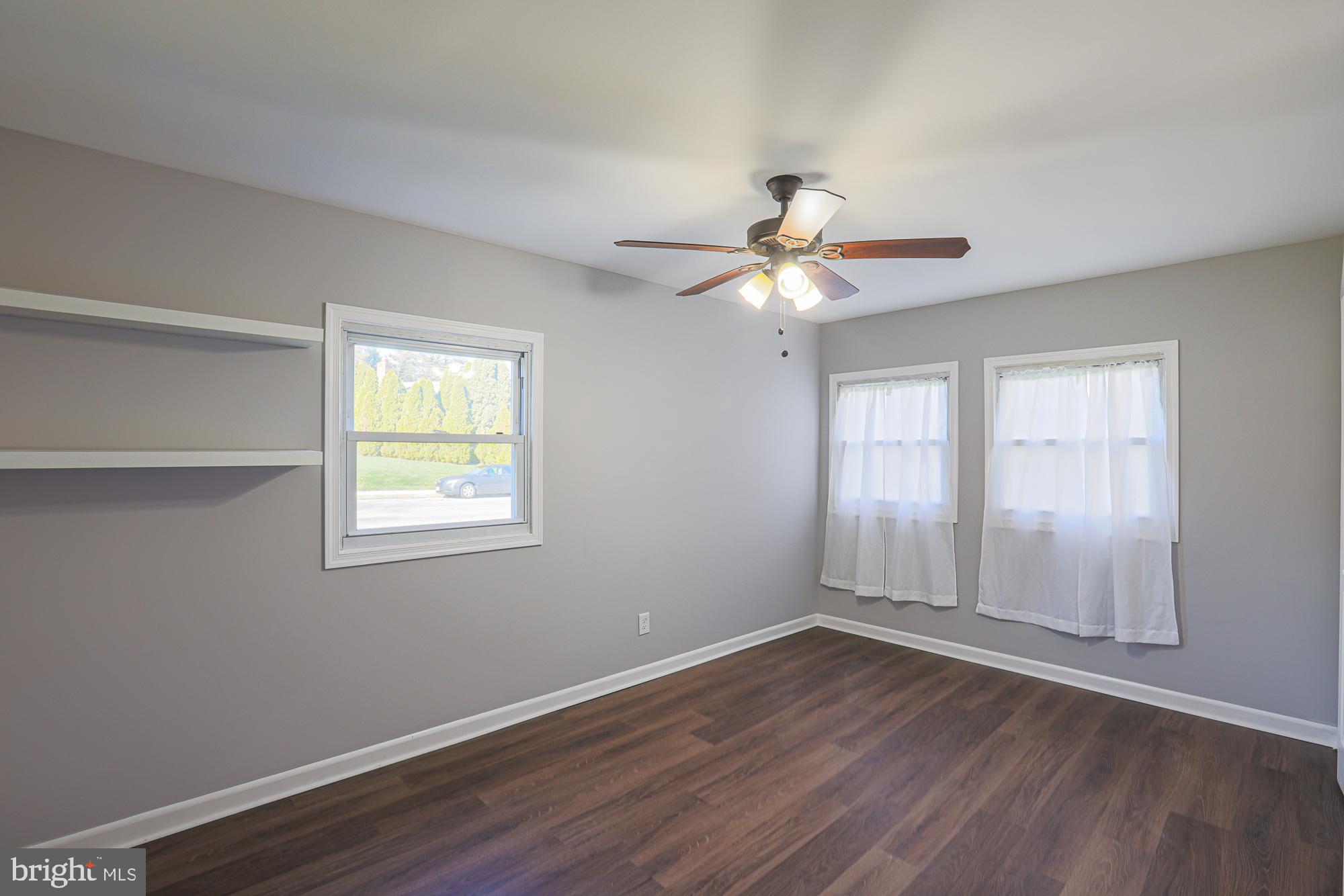 2507 Taney Road Baltimore, MD 21209 - Photo 24 of 58 an empty room with wooden floor fan and windows