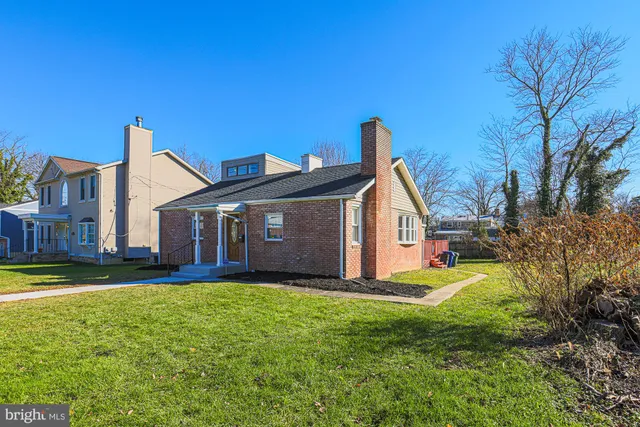 a view of a house with a big yard and large trees