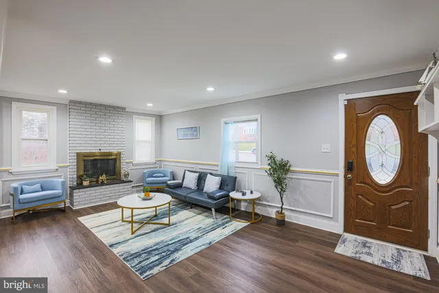 a living room with furniture a rug a fireplace and a window