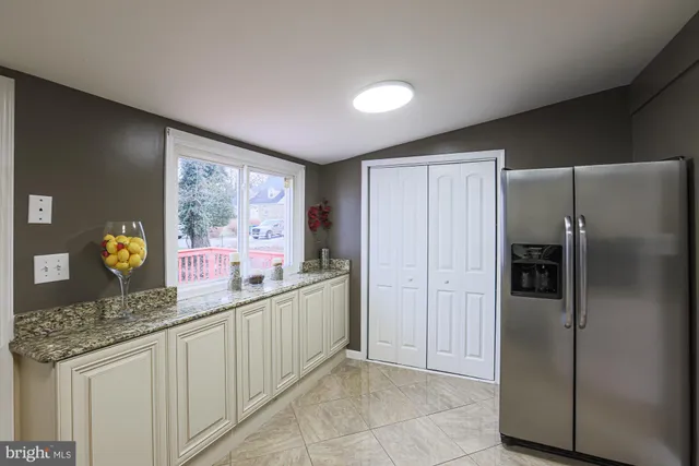 a kitchen with stainless steel appliances granite countertop a refrigerator and a stove