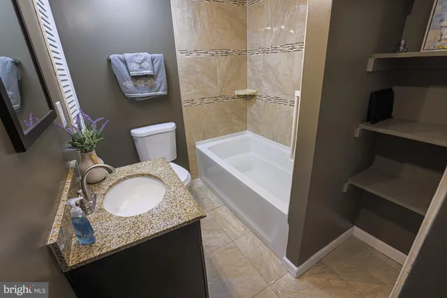 a bathroom with a granite countertop sink mirror vanity and toilet