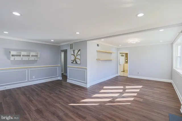 a view of empty room with wooden floor