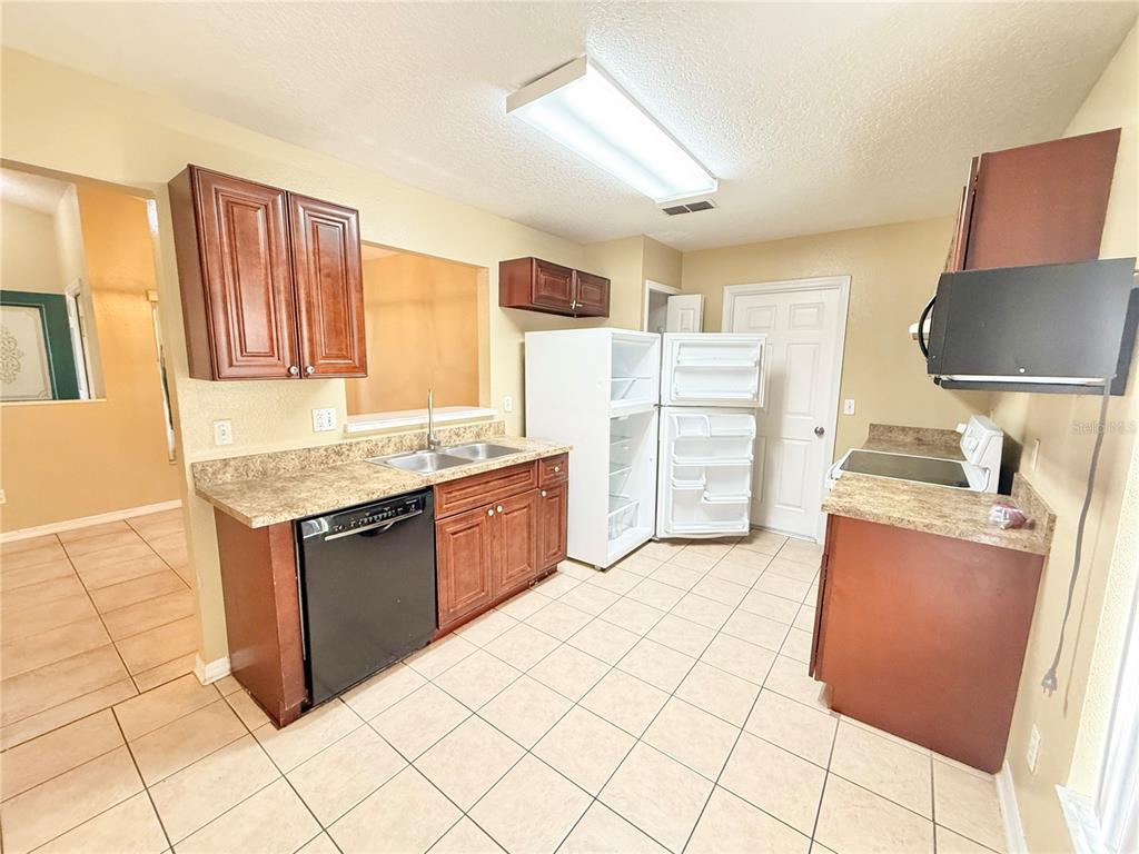 4695 Prairie Point Boulevard Kissimmee, FL 34746 - Photo 9 of 27 a kitchen with stainless steel appliances granite countertop a stove a sink and a refrigerator