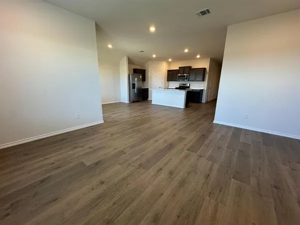a view of kitchen with kitchen island wooden floor center island and stainless steel appliances