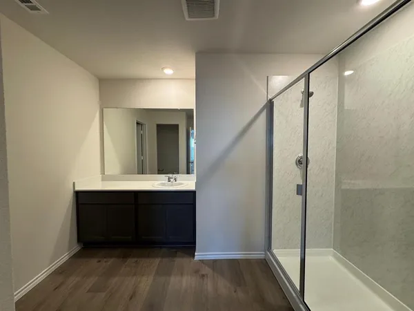 a bathroom with a double vanity sink mirror and shower