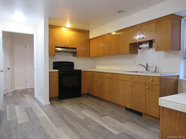 a kitchen with a sink cabinets and wooden floor