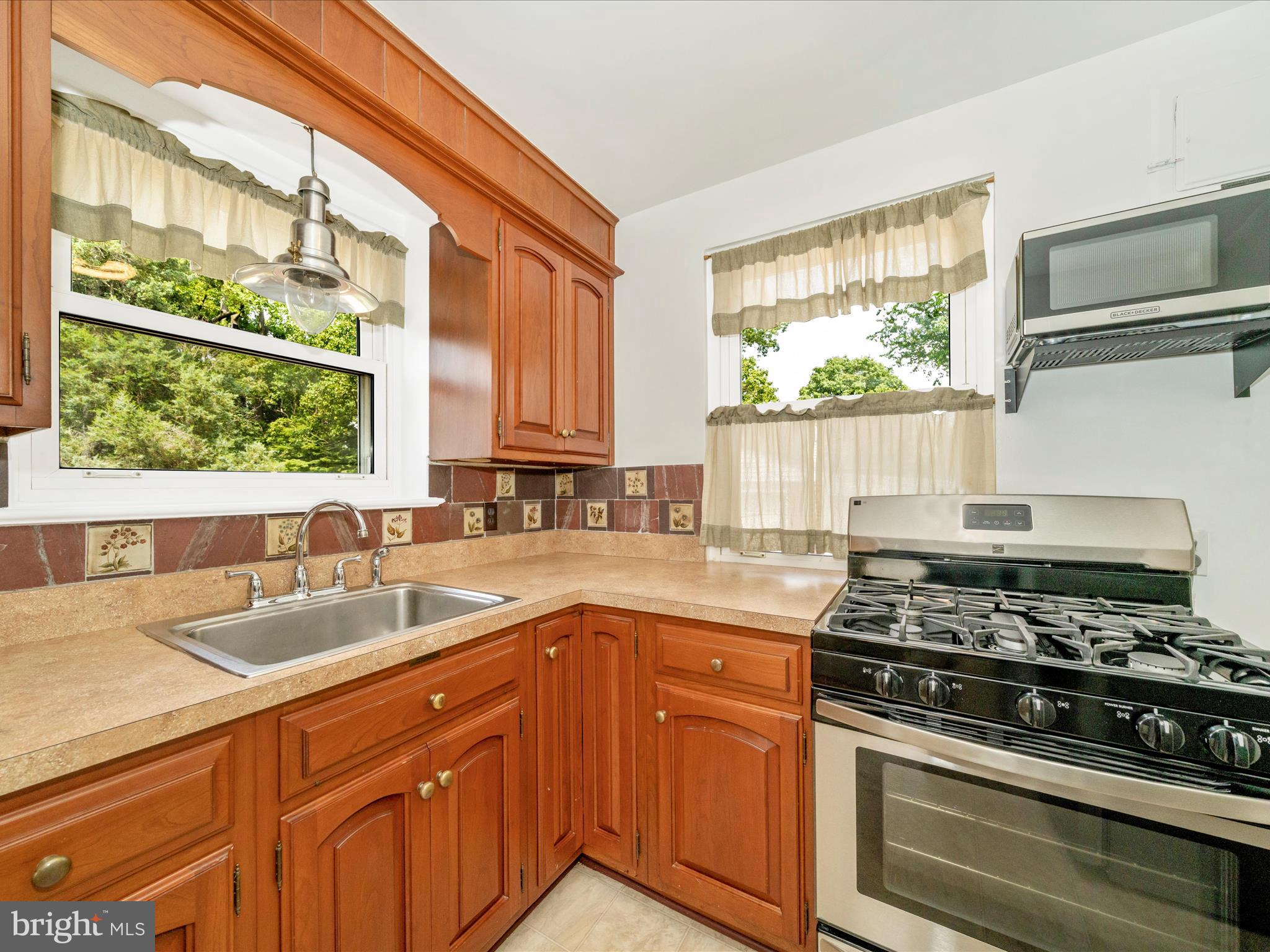 9405 Flower Avenue Silver Spring, MD 20901 - Photo 14 of 51 a kitchen with granite countertop a sink stainless steel appliances and cabinets
