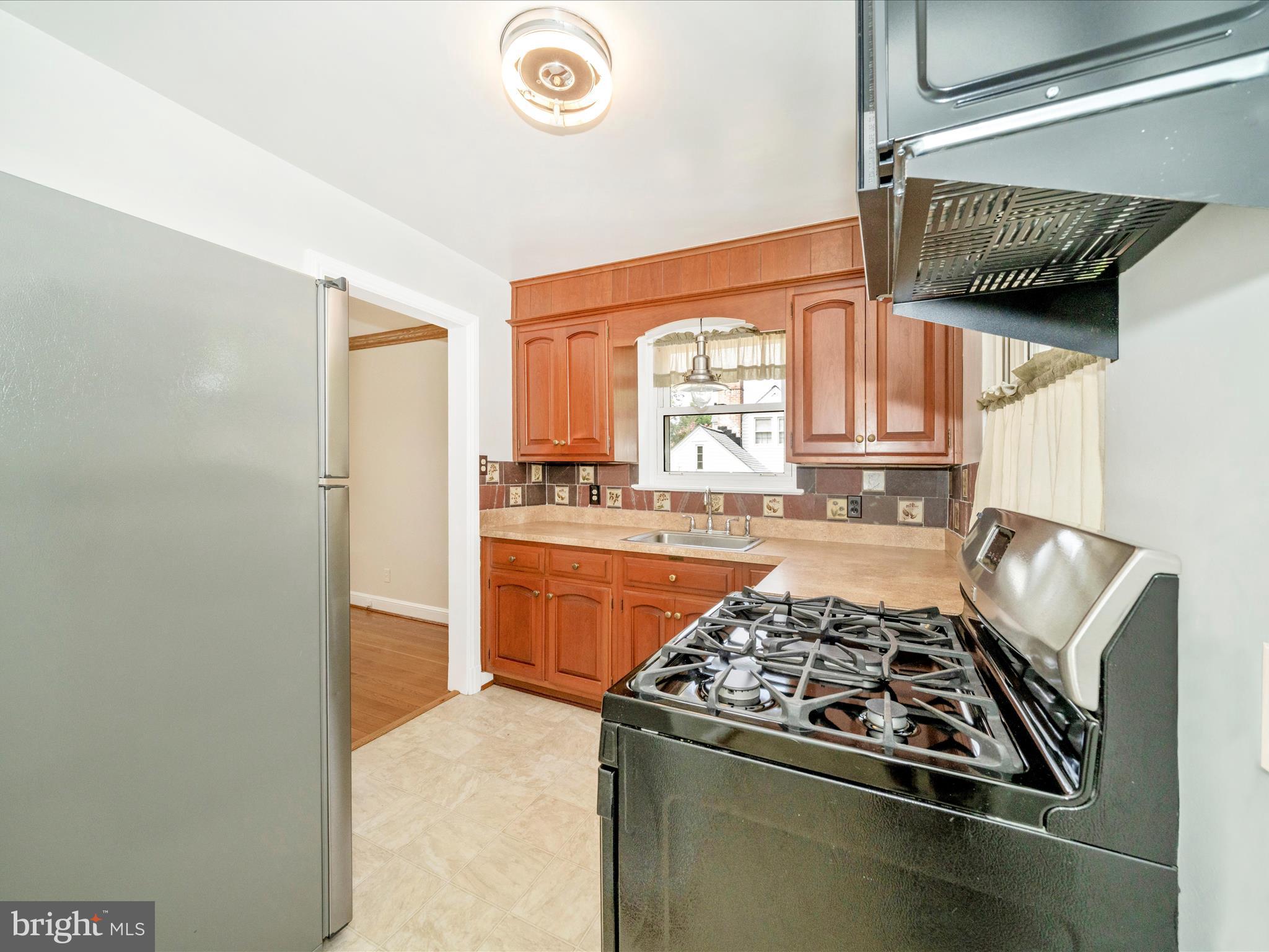 9405 Flower Avenue Silver Spring, MD 20901 - Photo 18 of 51 a kitchen with stainless steel appliances granite countertop a stove and a refrigerator