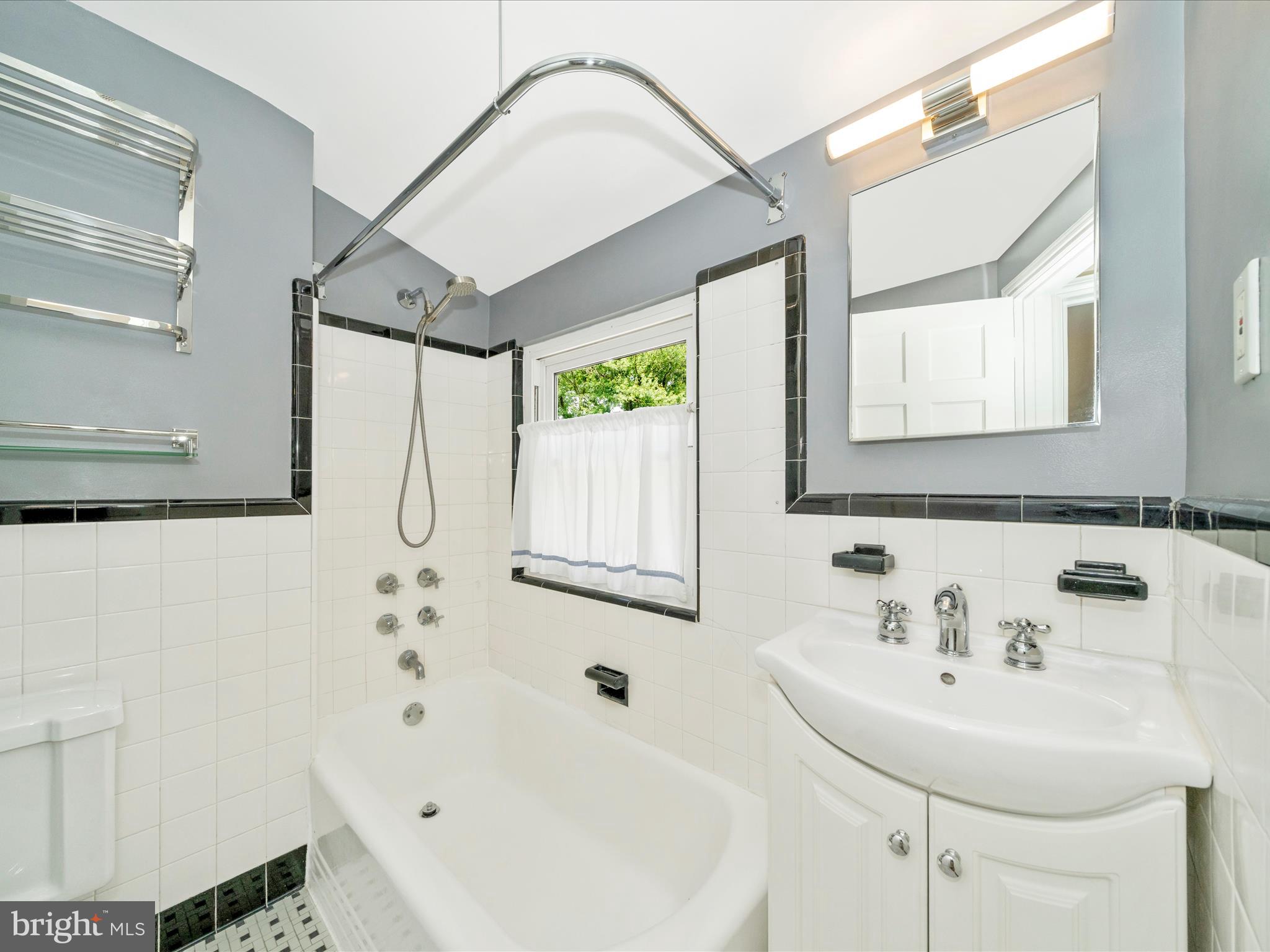 9405 Flower Avenue Silver Spring, MD 20901 - Photo 31 of 51 a bathroom with a sink a mirror and a bathtub