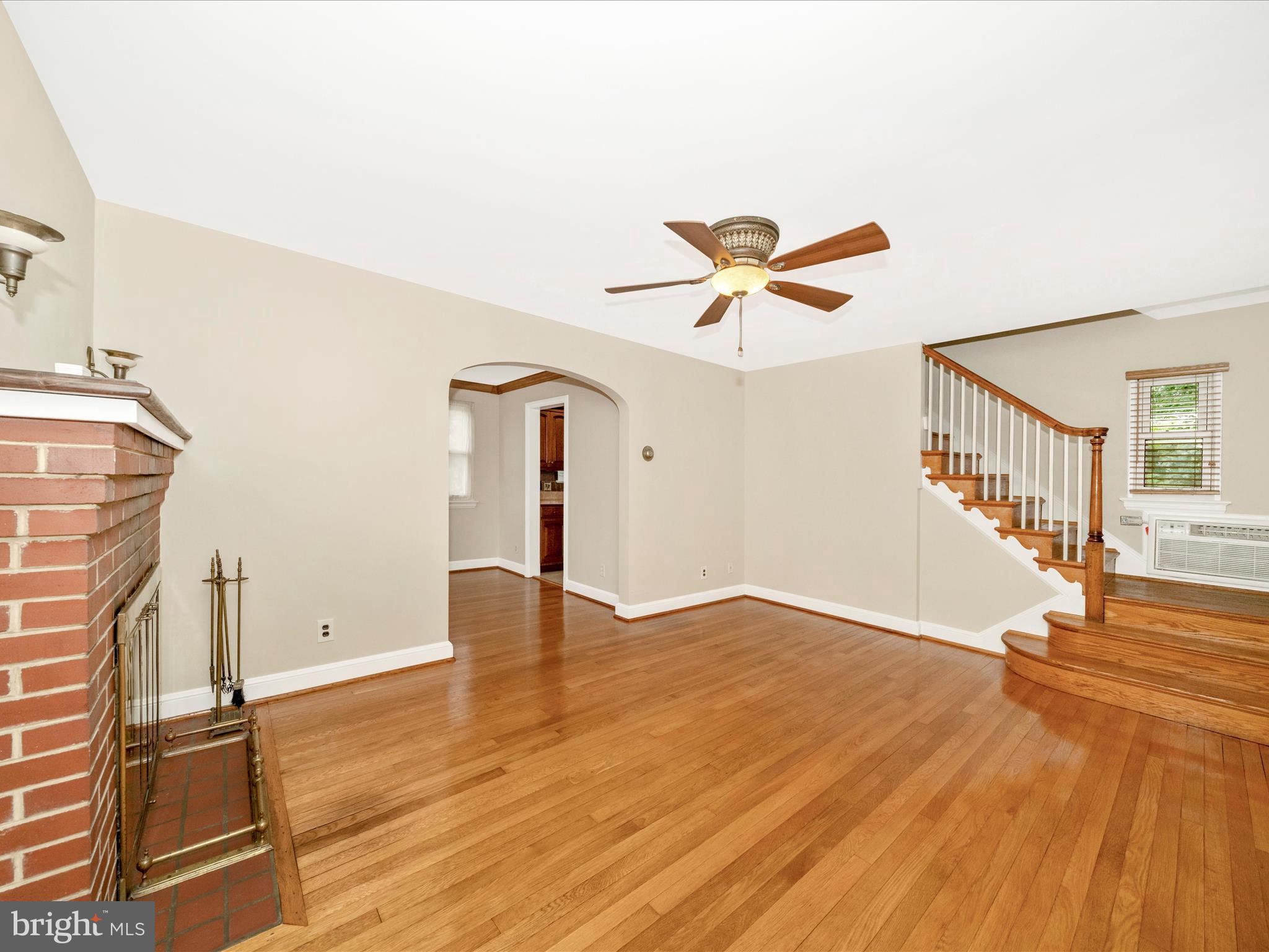 9405 Flower Avenue Silver Spring, MD 20901 - Photo 4 of 51 a view of a livingroom with wooden floor and a ceiling fan