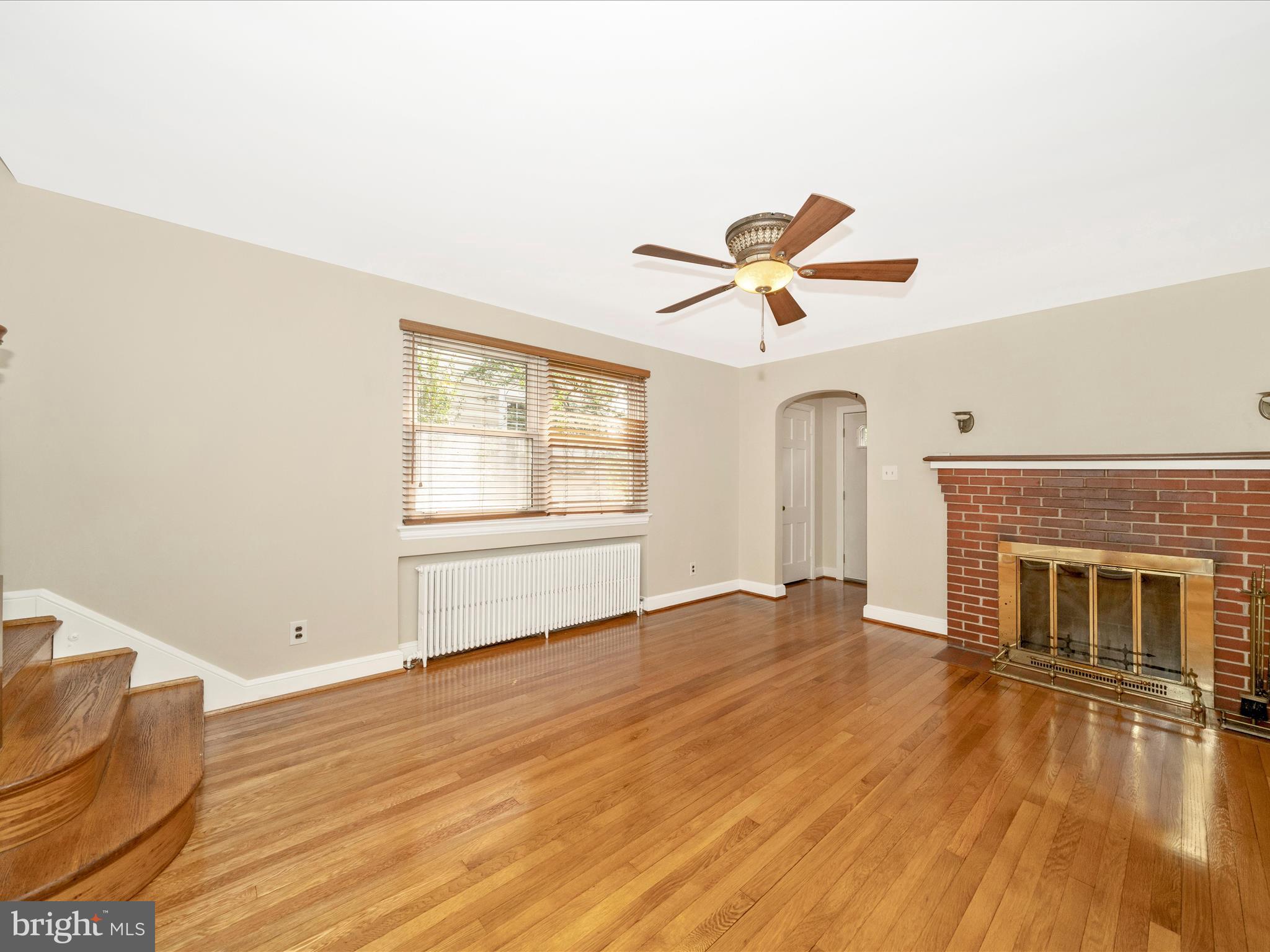9405 Flower Avenue Silver Spring, MD 20901 - Photo 6 of 51 a view of empty room with wooden floor and fireplace