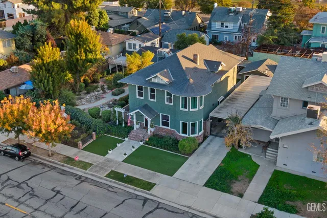 a front view of a house with a garden and trees