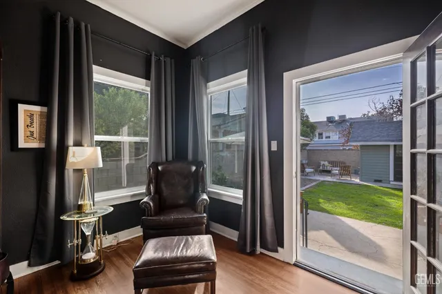 a kitchen with granite countertop a stove a sink a dining table and chairs with wooden floor