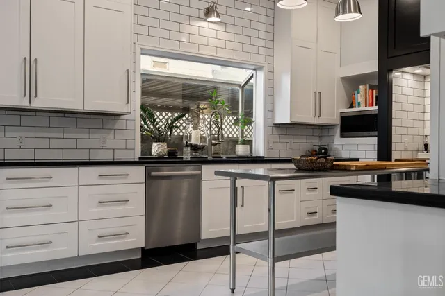 a kitchen with white cabinets and stainless steel appliances