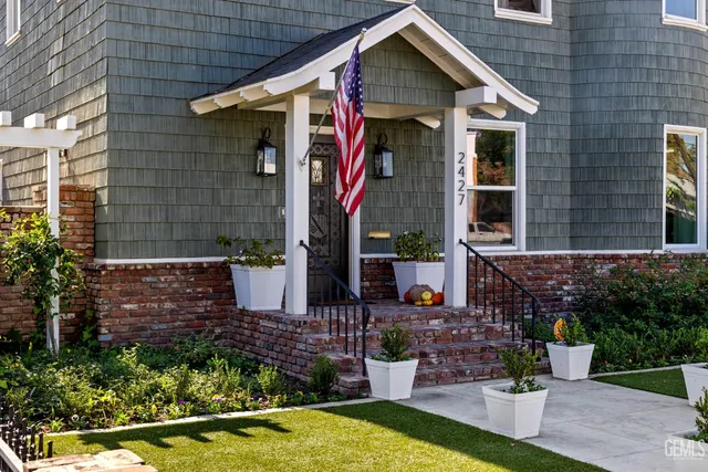 a view of a hallway with wooden floor and a potted plant on a table