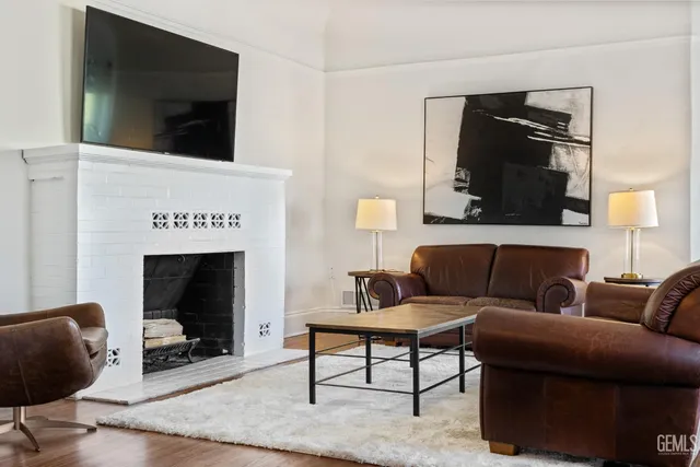 a living room with furniture a fireplace and a flat screen tv