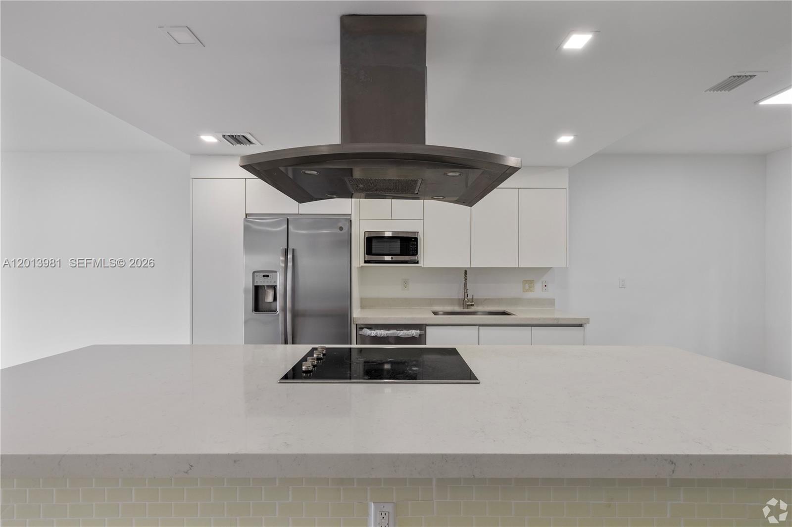 434 Southwest 10th Street, Unit A Miami, FL 33130 - Photo 4 of 23 a kitchen with stainless steel appliances a stove a sink and white cabinets