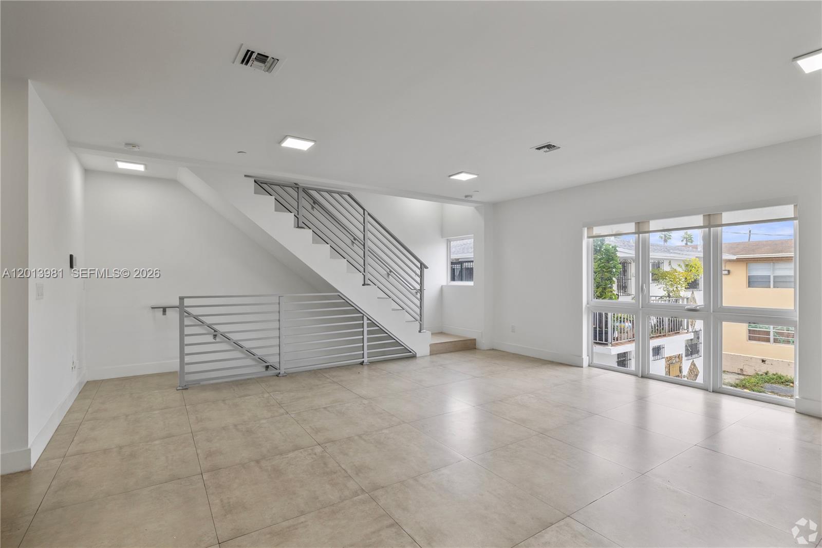 434 Southwest 10th Street, Unit A Miami, FL 33130 - Photo 6 of 23 an empty room with wooden floor and windows