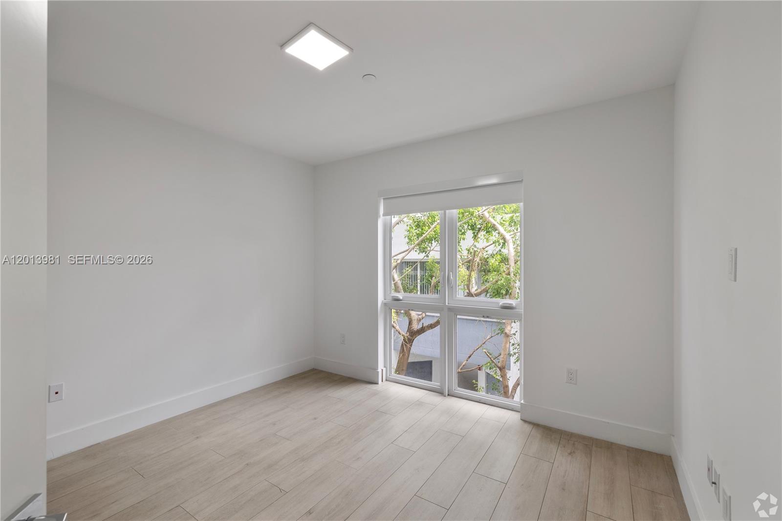 434 Southwest 10th Street, Unit A Miami, FL 33130 - Photo 8 of 23 an empty room with wooden floor and windows