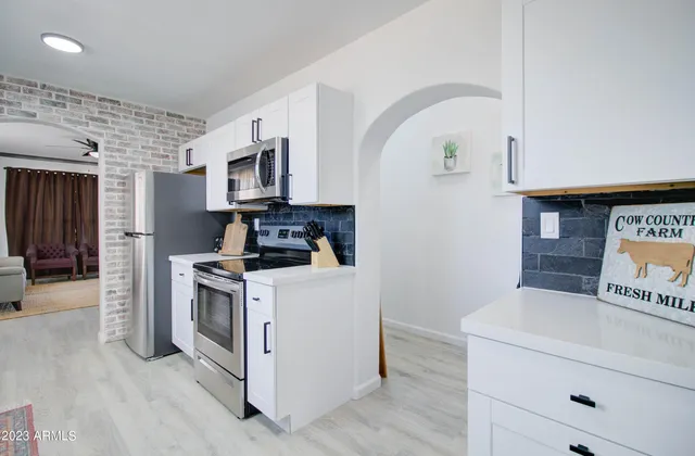 a kitchen with stainless steel appliances granite countertop a stove a sink and a refrigerator