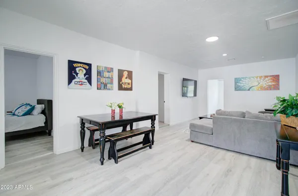 a living room with furniture and paintings on the wall