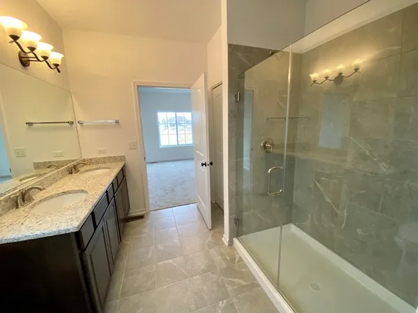 a bathroom with a granite countertop sink a mirror and a bathtub