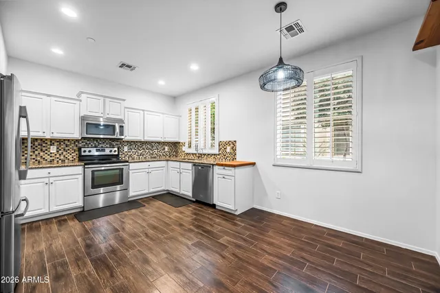 a kitchen with granite countertop white cabinets and appliances