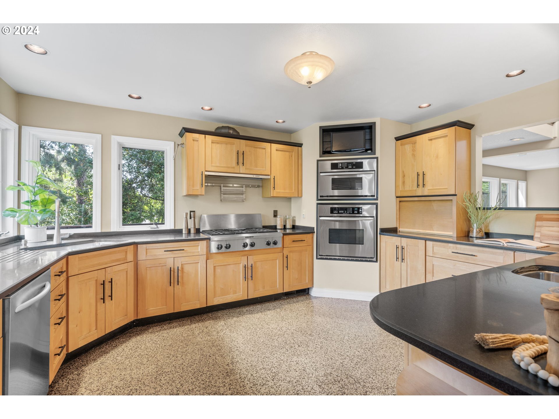 4803 Southwest Stonebrook Court Portland, OR 97239 - Photo 13 of 40 a kitchen with stainless steel appliances granite countertop a stove sink and cabinets
