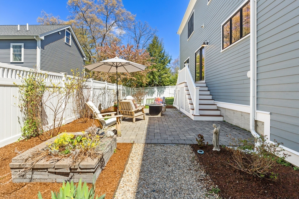 24 Pine Knoll Road Lexington, MA 02420 - Photo 36 of 41 a view of a patio with couches table and chairs under an umbrella