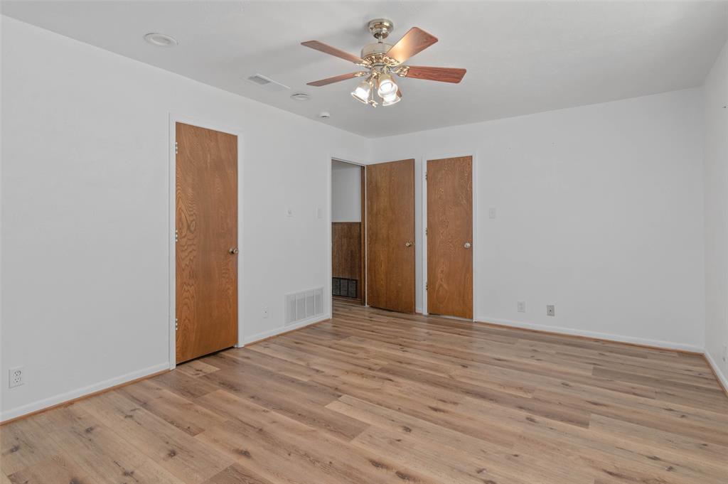 301 East 6th Street Krum, TX 76249 - Photo 20 of 29 Bedroom featuring wood-like flooring, ceiling fan and large window allowing in plenty of natural light.
