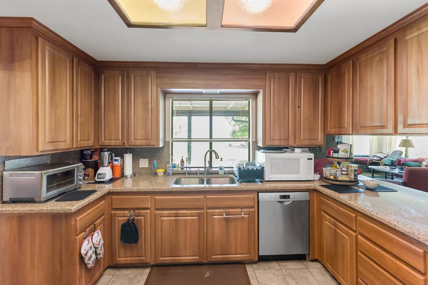 4776 Stetson Road Clovis, CA 93619 - Photo 16 of 49 a kitchen with stainless steel appliances granite countertop a sink a stove a refrigerator cabinets and wooden floor
