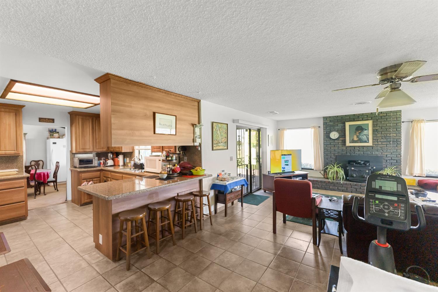 4776 Stetson Road Clovis, CA 93619 - Photo 17 of 49 a large dining hall with stainless steel appliances granite countertop a stove top oven a dining table and chairs with the living room view
