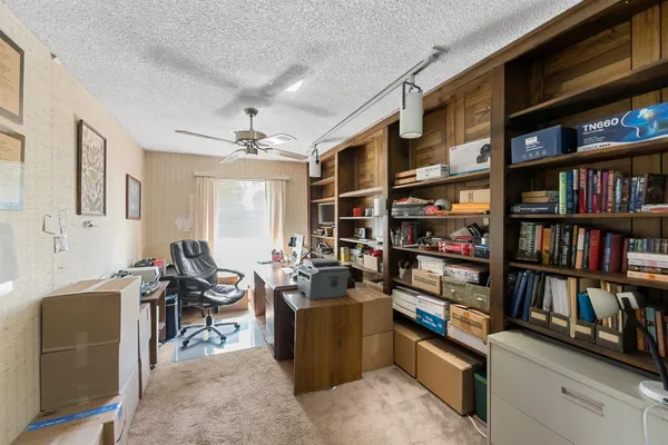 a view of a workspace with furniture and a book shelf