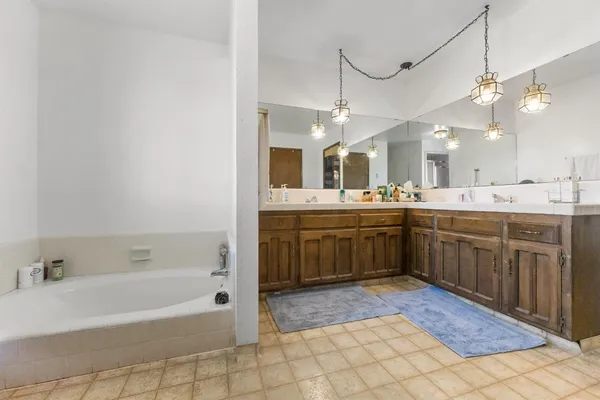 a large bathroom with a sink a vanity a mirror and bathtub