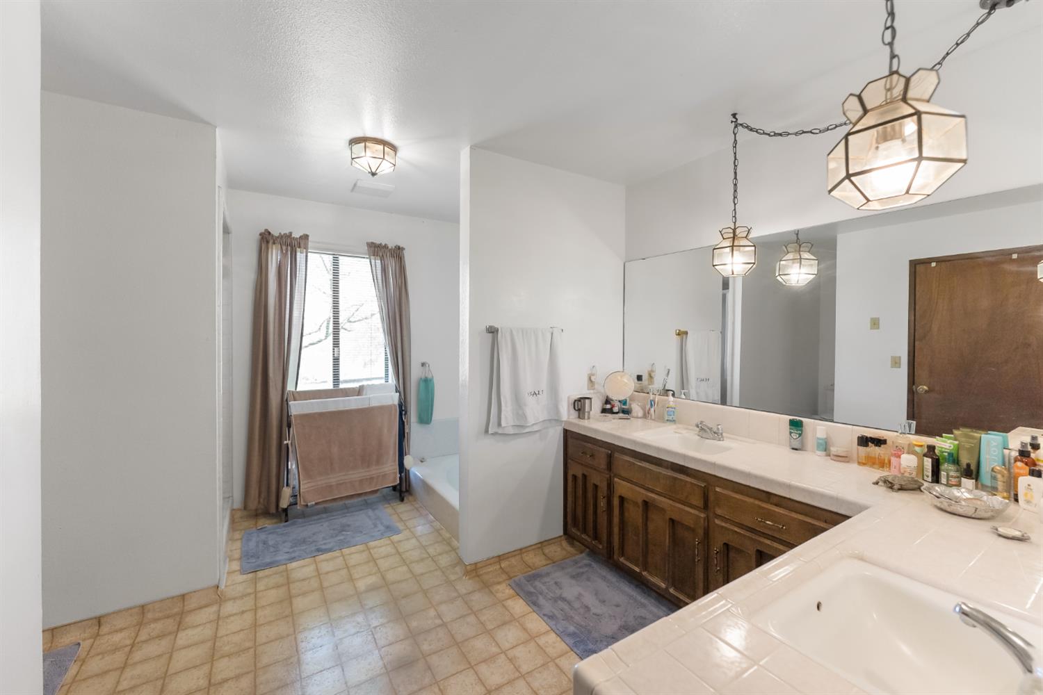 4776 Stetson Road Clovis, CA 93619 - Photo 30 of 49 a bathroom with a double vanity sink a mirror and a bathtub