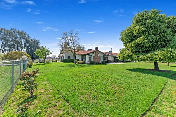 a view of an house with backyard space and garden