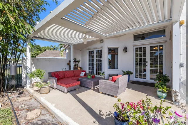 a view of potted plants and a bench in front of a house