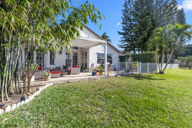an aerial view of a house with a garden and lake view