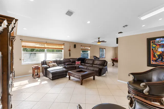 a living room with furniture a piano and a chandelier