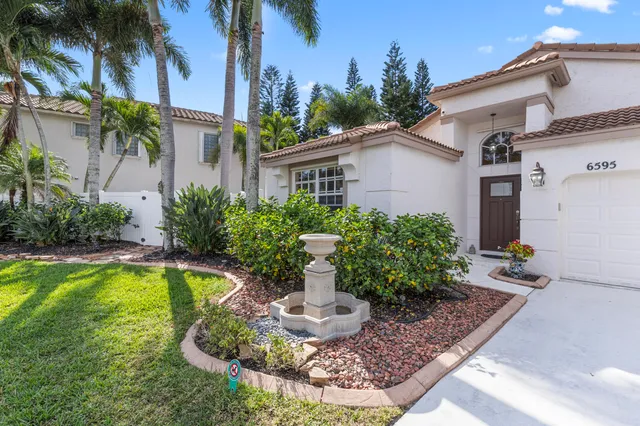 a front view of a house with a yard outdoor seating and lake view