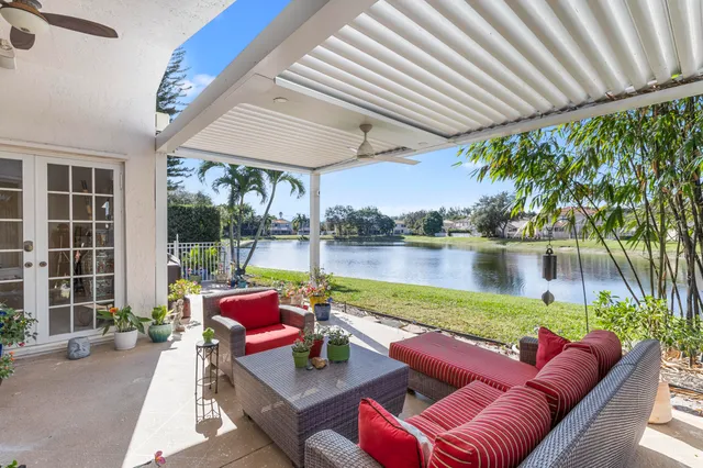 a front view of a house with a garden and lake view
