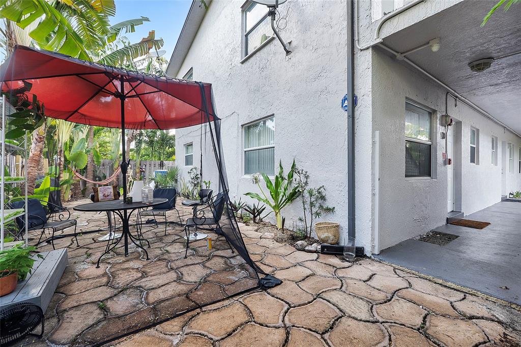 2741 Northeast 8th Avenue, Unit 10 Wilton Manors, FL 33334 - Photo 14 of 28 a view of a patio with a table and chairs under an umbrella