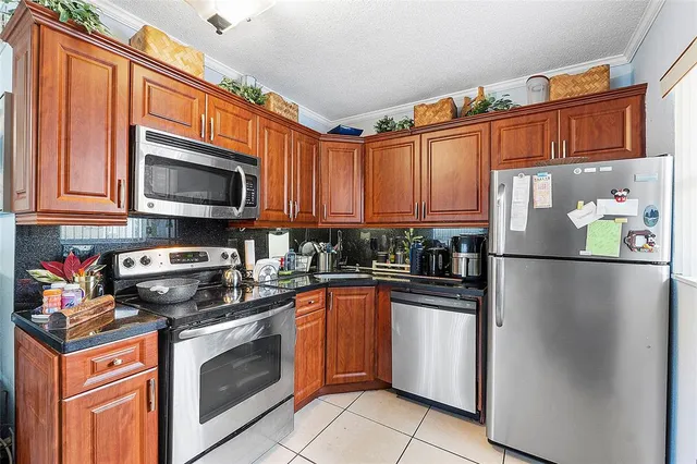 a kitchen with stainless steel appliances granite countertop a refrigerator stove top oven a sink and dishwasher